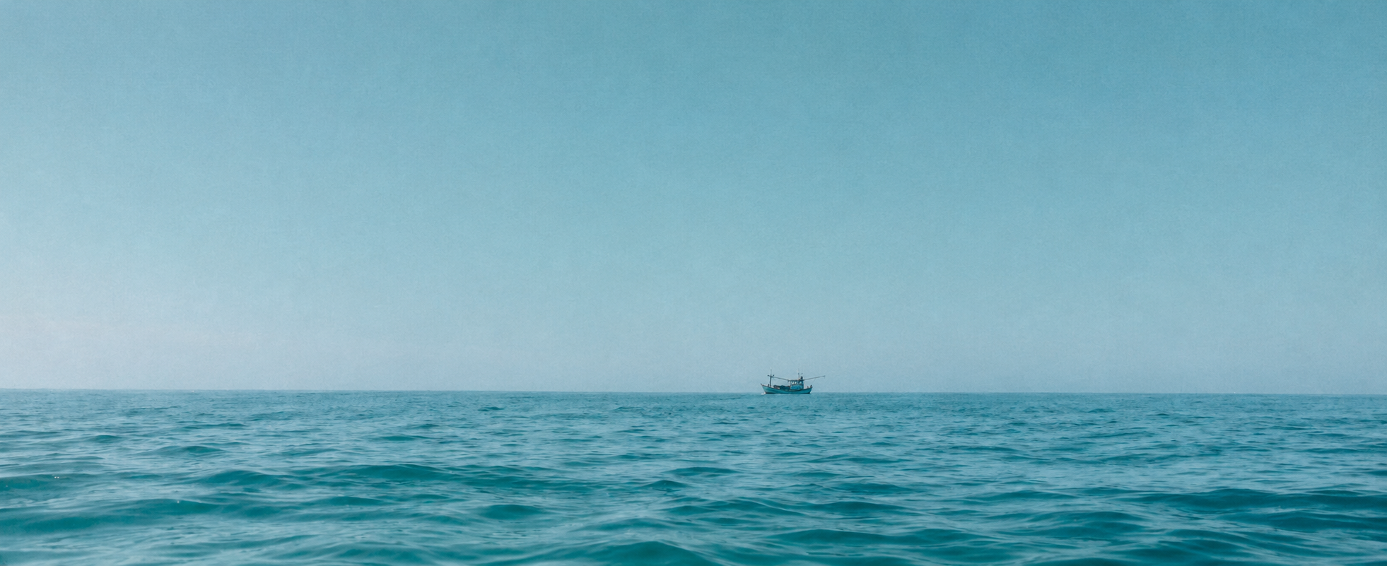 Traditional sea boat on the open ocean horizon of Sri Lanka